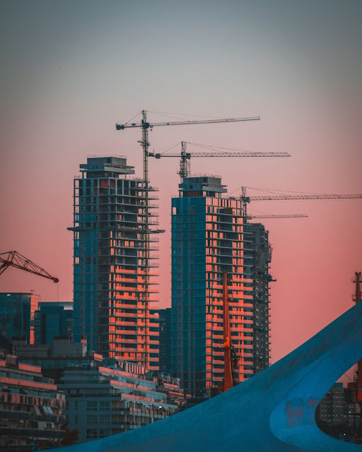 Skyline view of multiple tower cranes and skyscrapers in a city