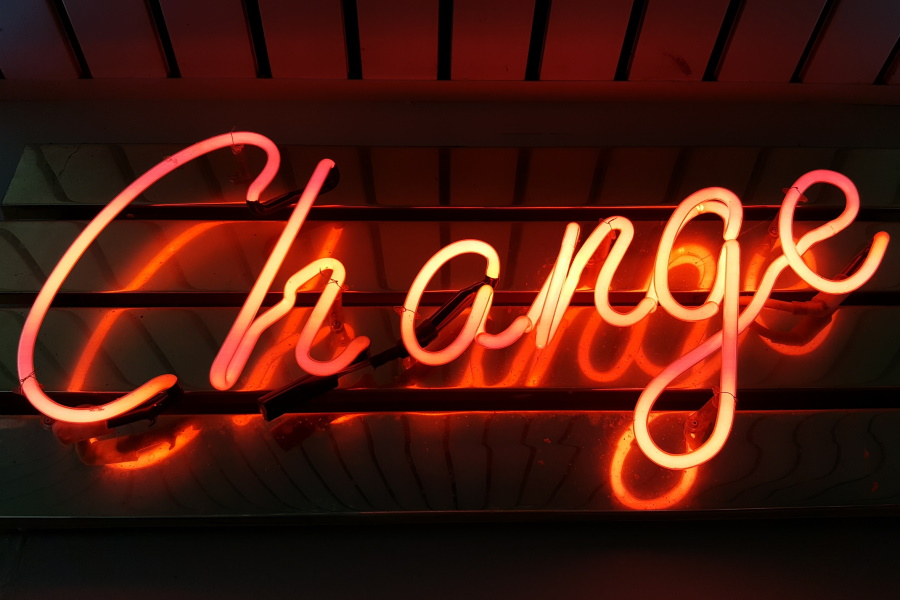 Orange neon sign showing script style text "Change"