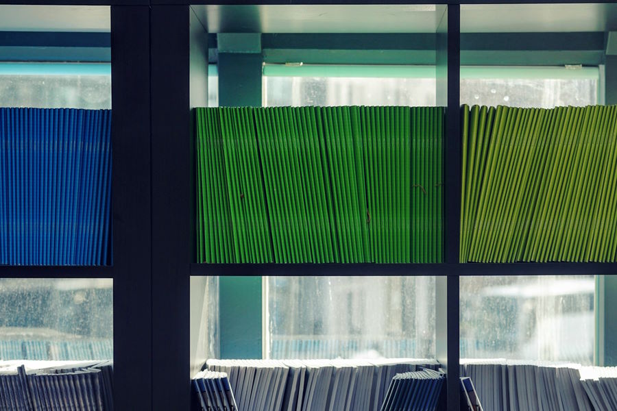 Different colour folders on an office bookshelf