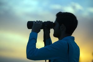 man with binoculars searches 900