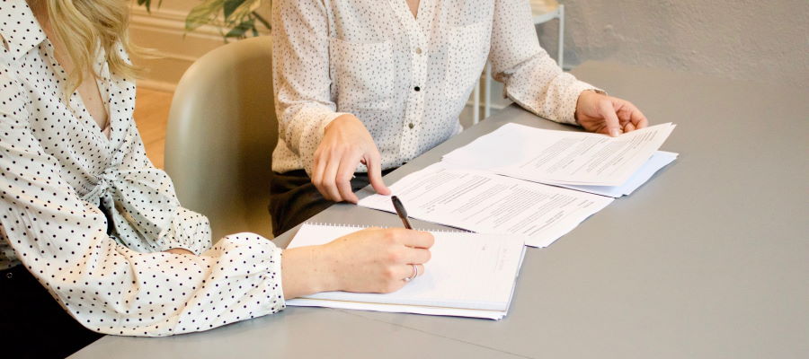 Two consultants at a desk discussing a tender proposal